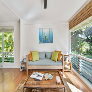 A bright living room with a comfortable couch, a coffee table, and a large window that enhances the inviting atmosphere.