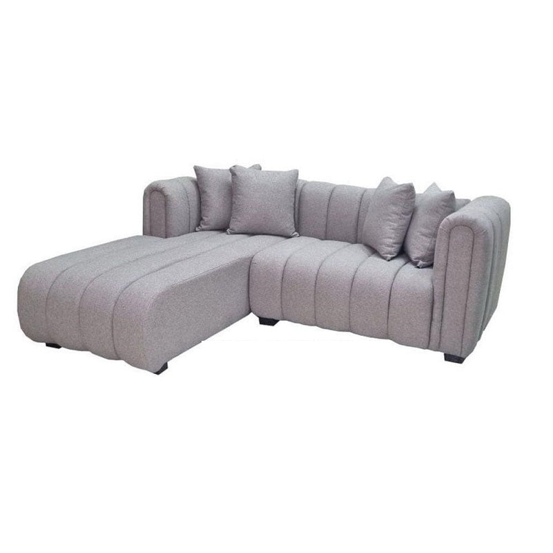 A stylish grey sectional couch featuring plush pillows, enhancing the comfort of the room.