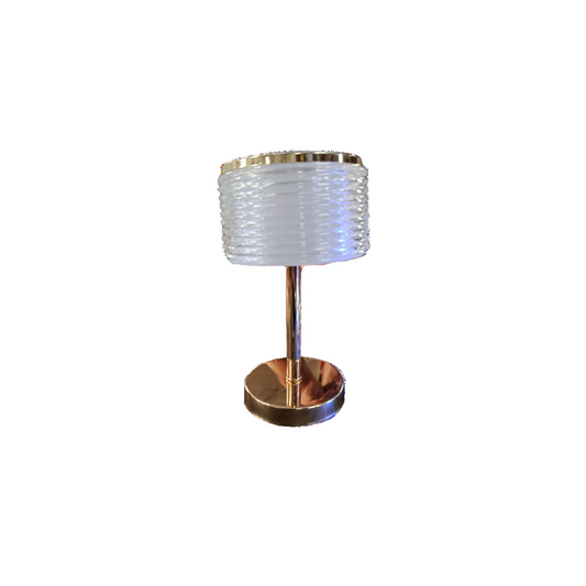 A lamp with a white shade illuminated against a solid black background.